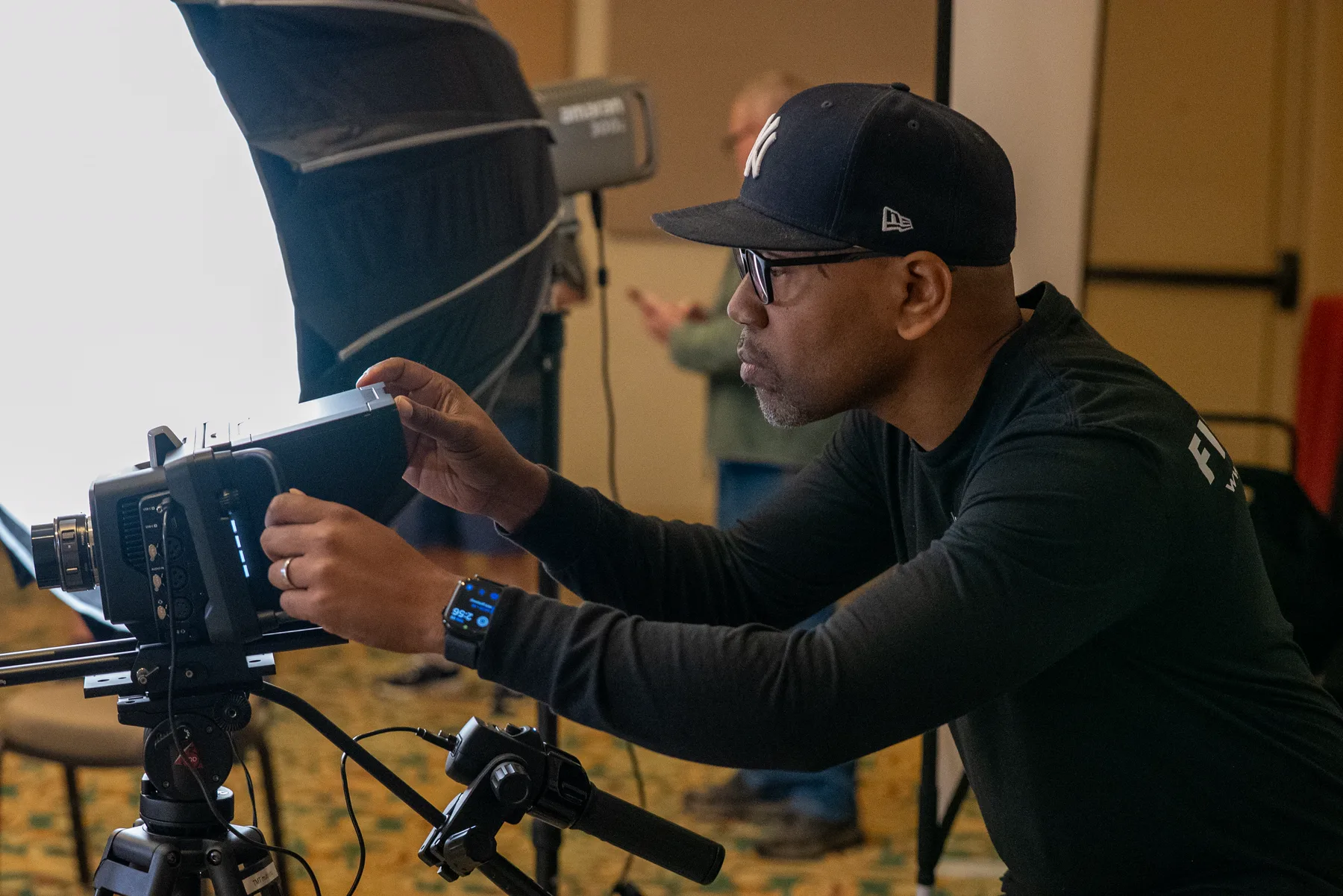 A studio owner operating a cinema camera on set